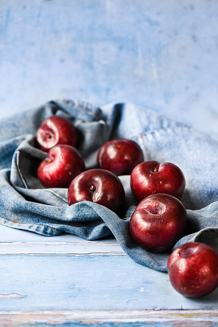Red plums on denim