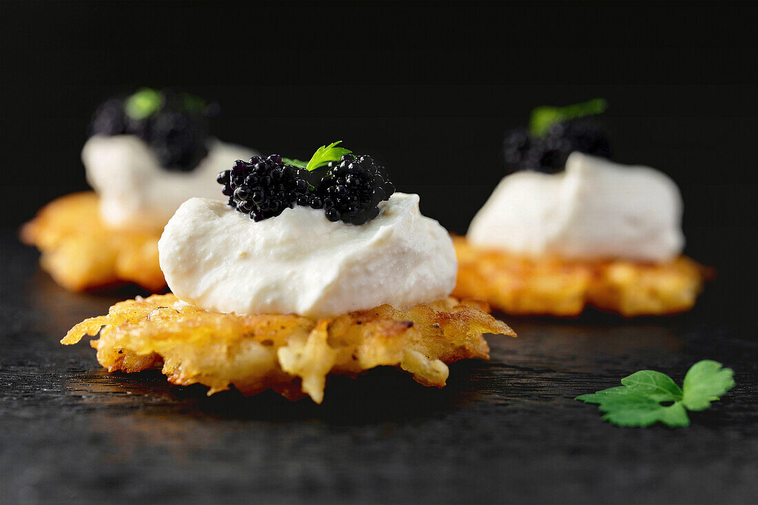 Mini rösti garnished with horseradish cream and black lumpfish caviar
