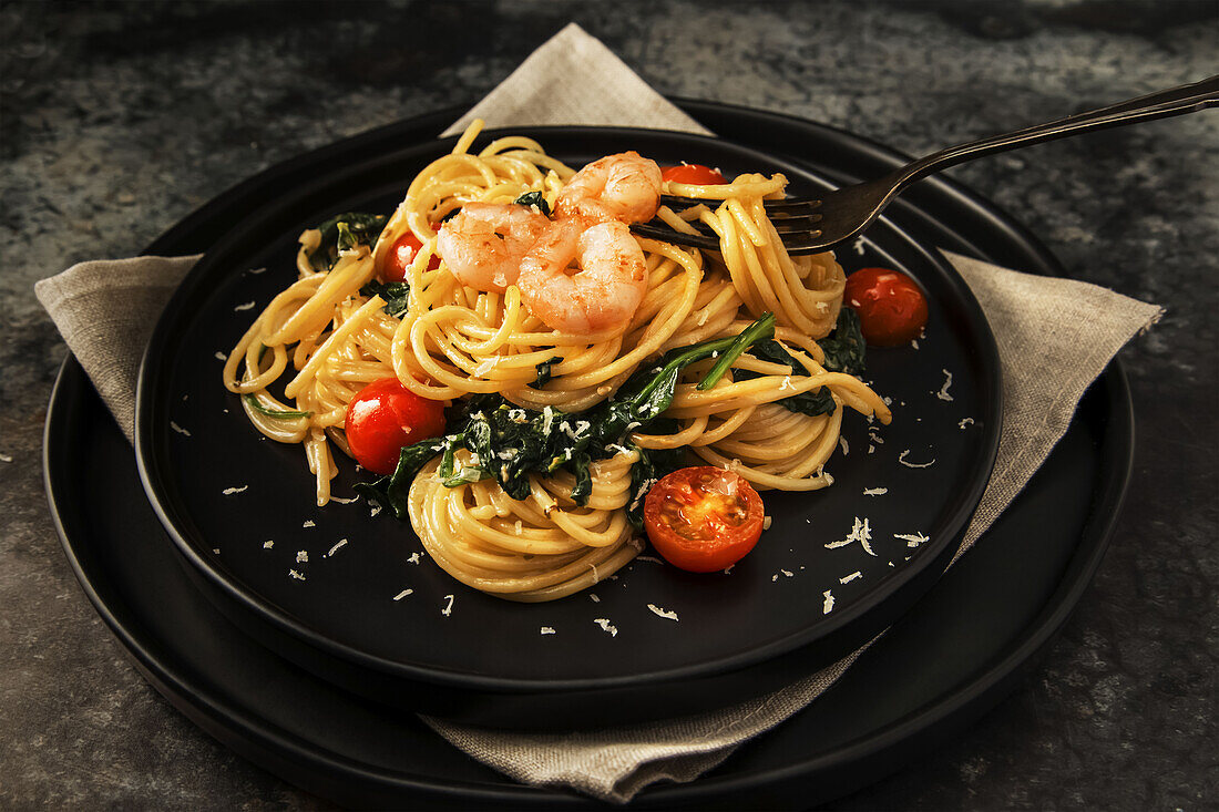 Spaghetti with prawns, spinach and tomatoes