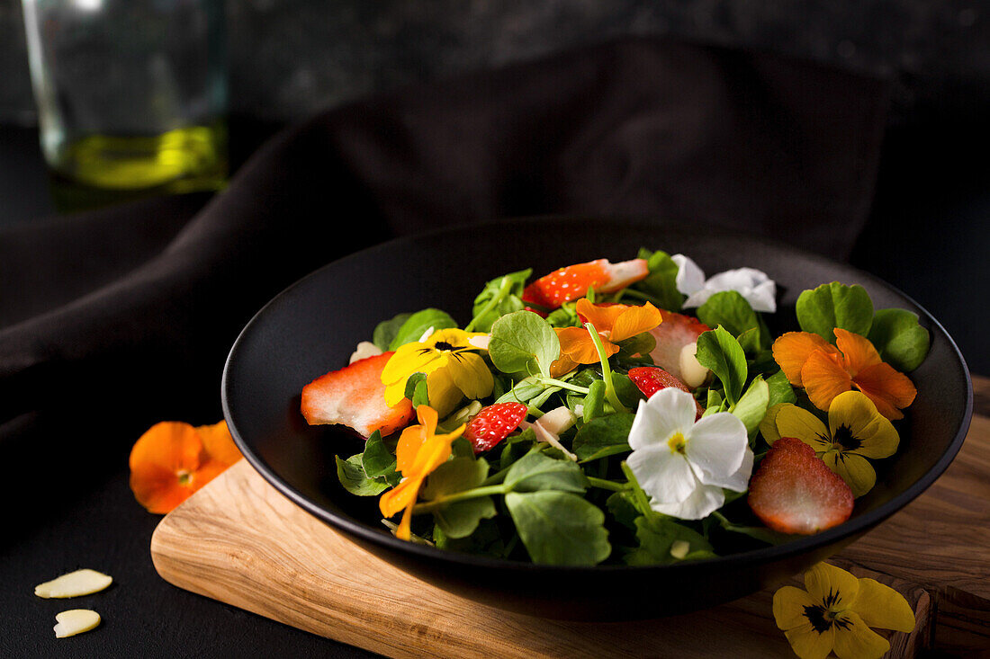 Colourful summer salad with strawberries and edible flowers