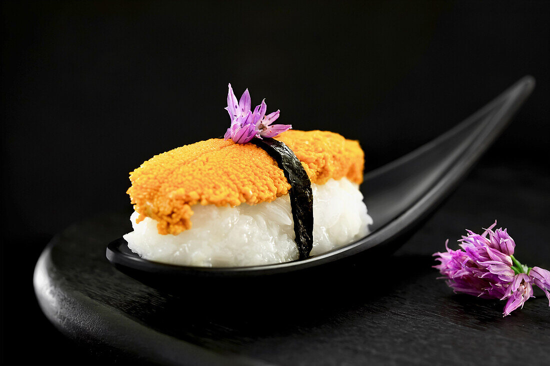 Nigiri-Sushi mit Seeigel und essbaren Schnittlauchblüten