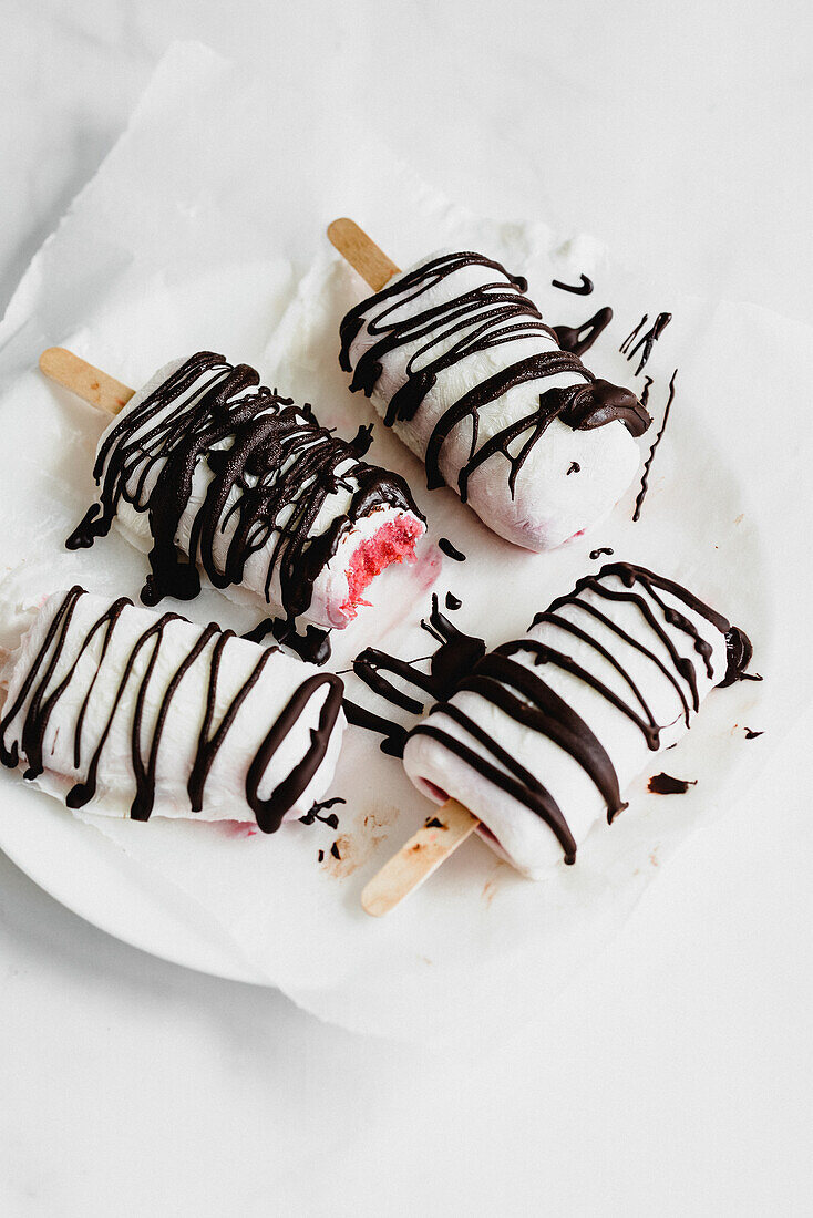 Strawberry ice cream on a stick with yoghurt icing