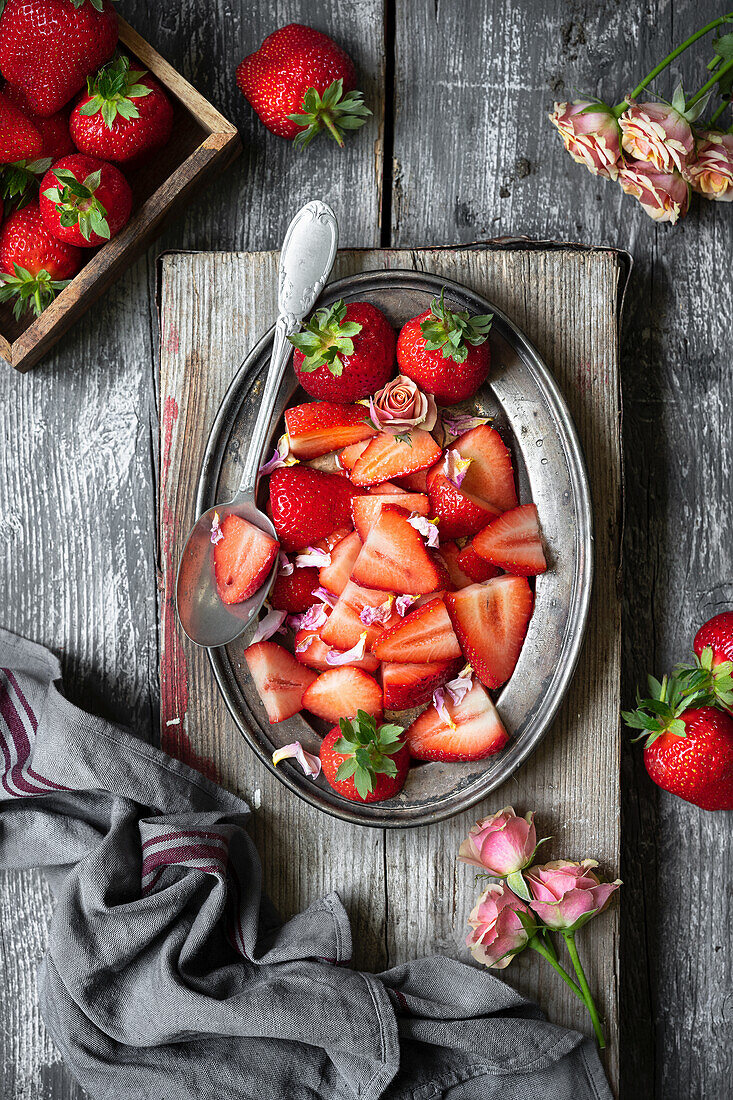 Freshly sliced strawberries on a metal plate