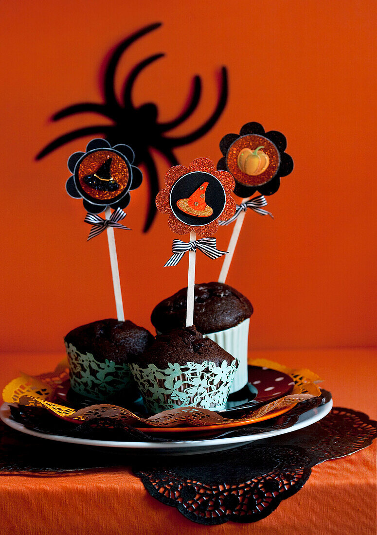 Halloween-Cupcakes mit dekorativen Kürbis- und Hexenhut-Motiven