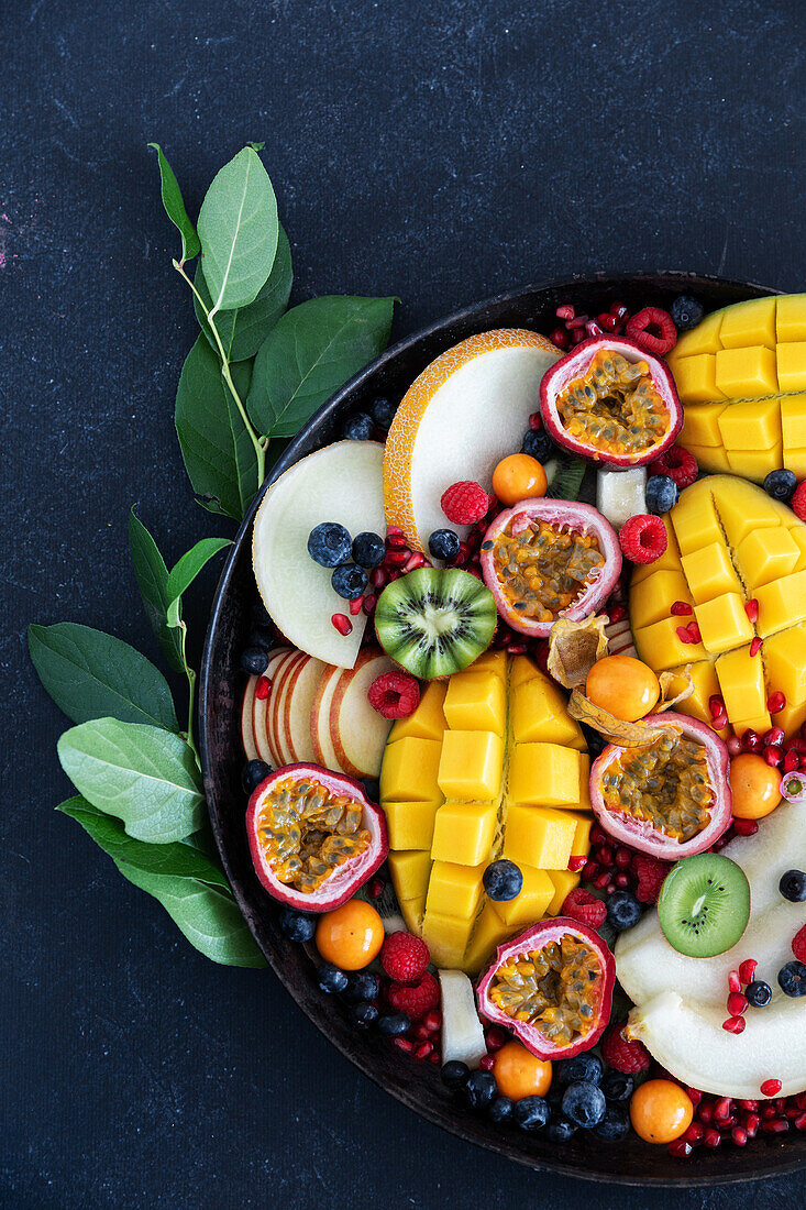 Colourful fruit platter with mango, passion fruit, kiwi and berries