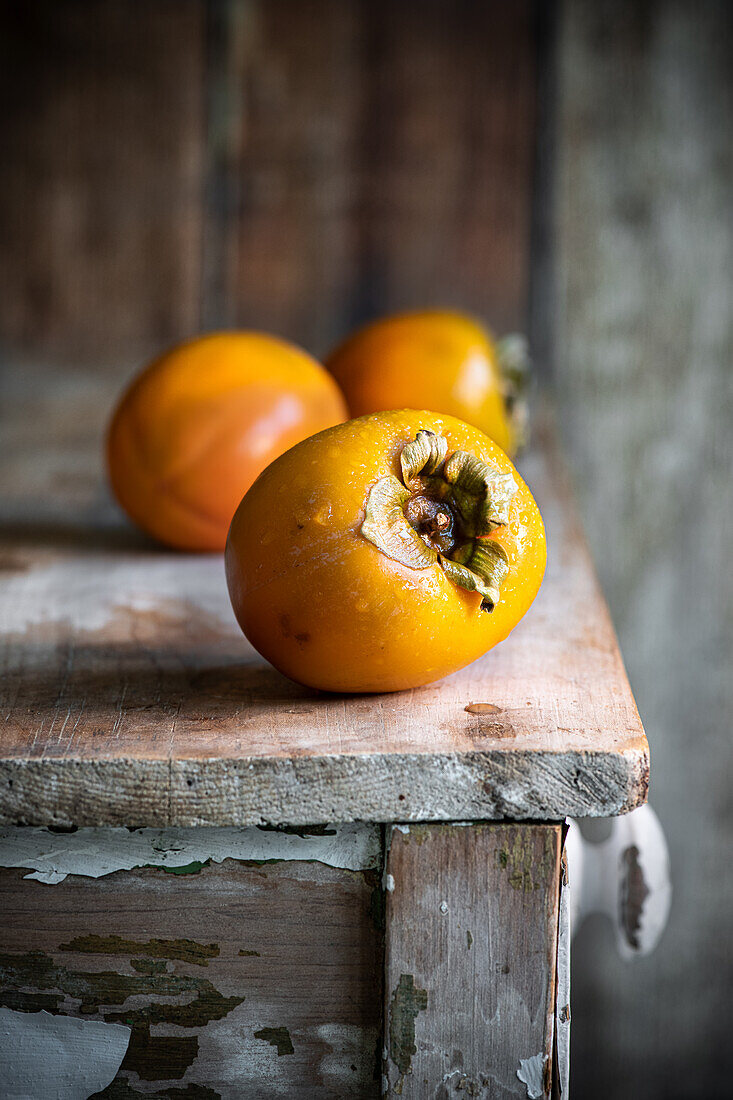 Fresh persimmons on a wooden table