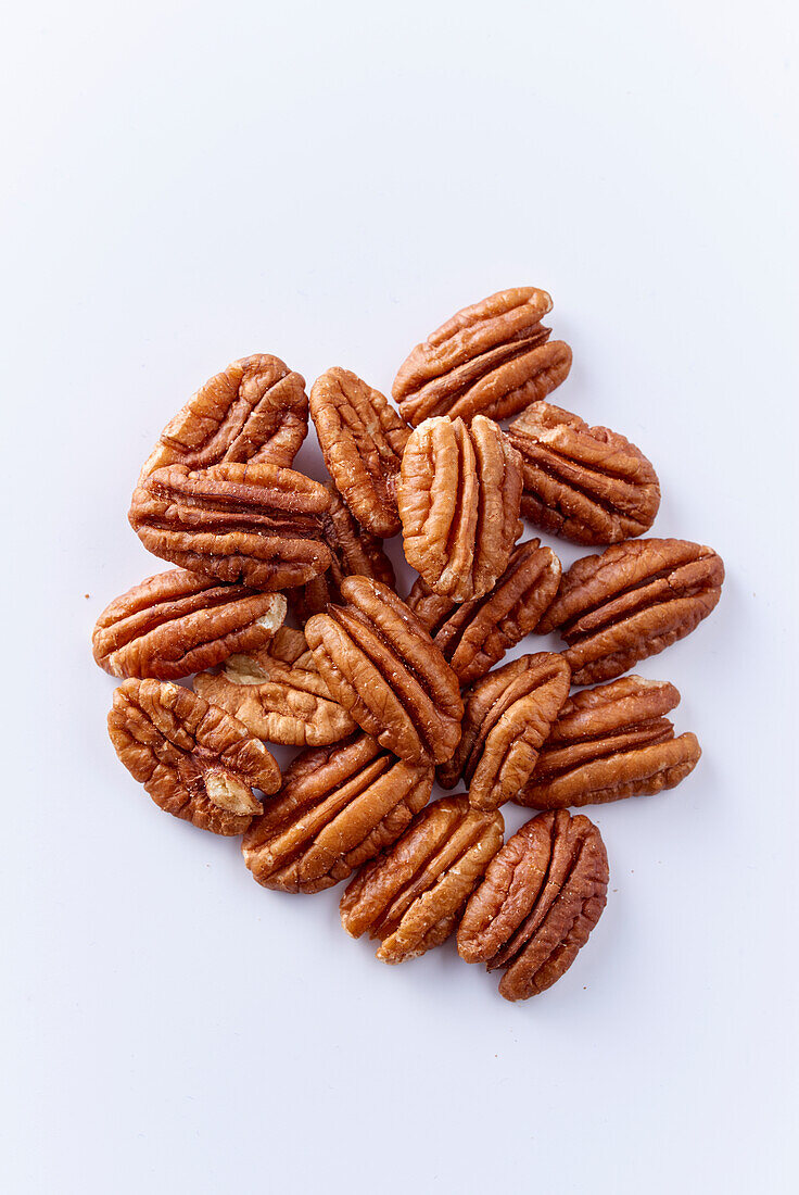 Pecan kernels on a white surface