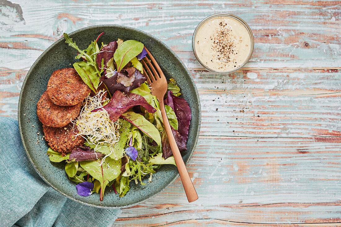 Colourful salad with vegan seed and bean patties