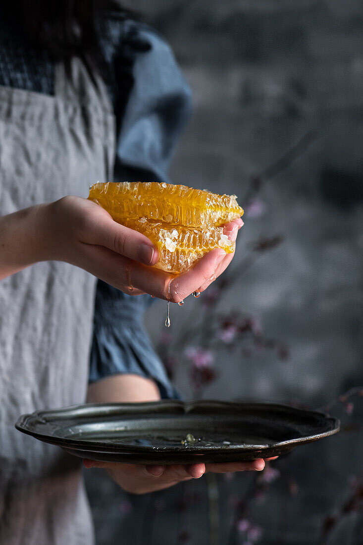 Woman holding dripping honeycomb