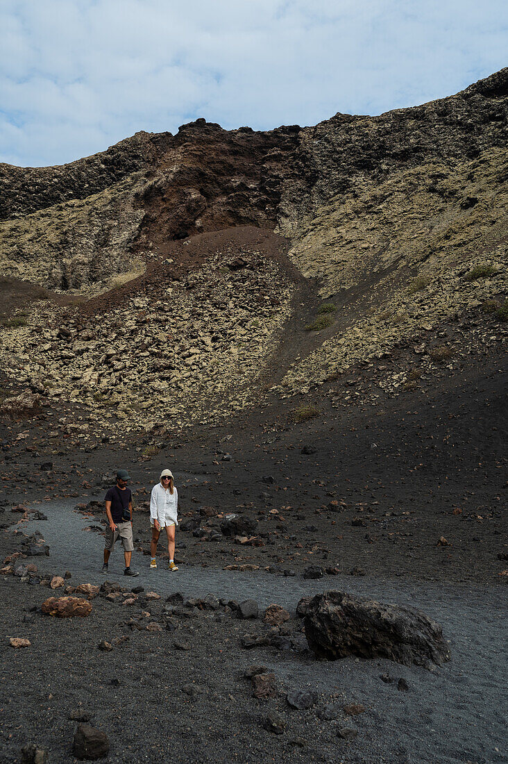 Volcan del Cuervo (Krähenvulkan), ein Krater, der auf einem Rundweg in einer kargen, felsigen Landschaft erkundet wird