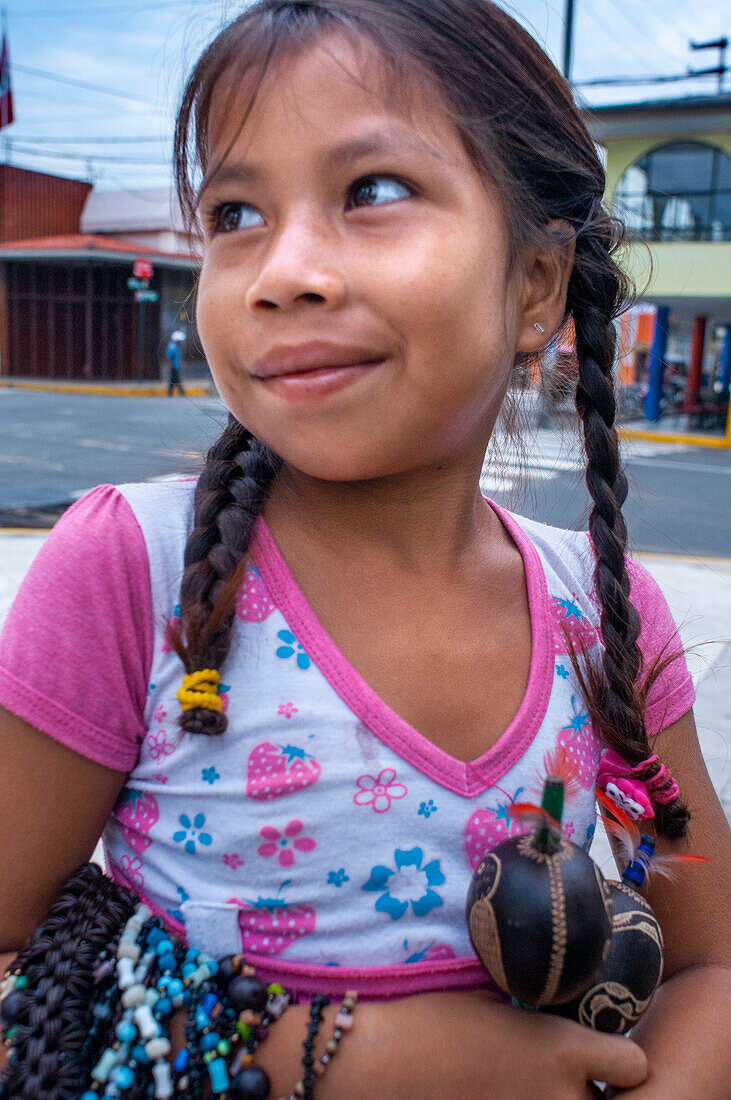 Ein junges Mädchen verkauft Kunsthandwerk im Zentrum von Iquitos, Peru, Südamerika