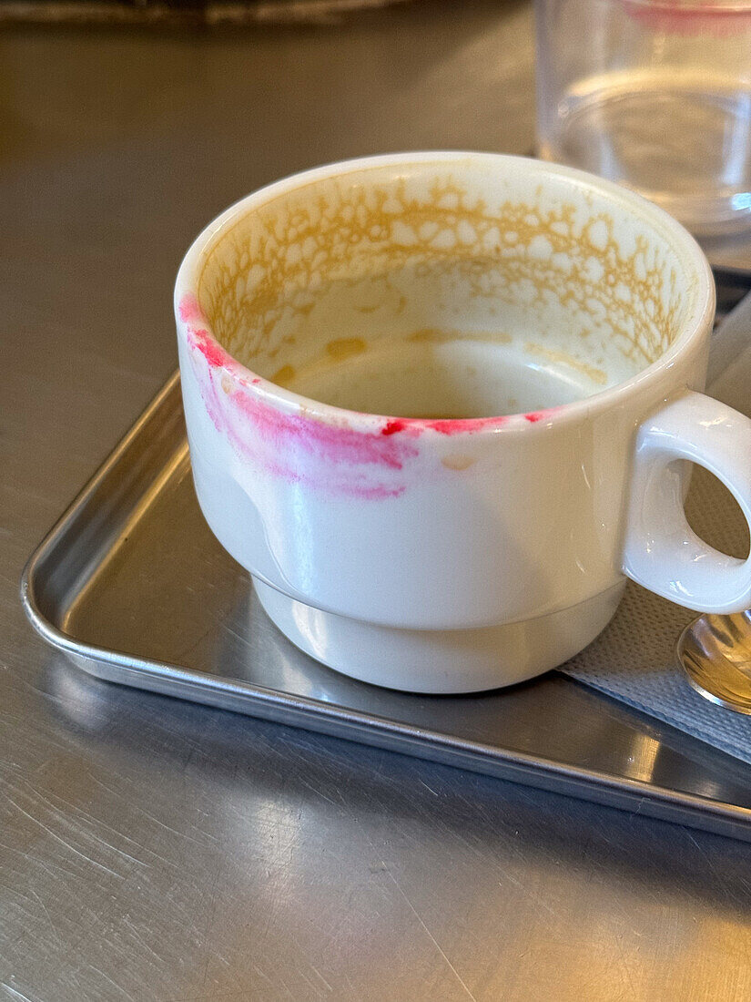 Female lipstick mark left on cup of coffee