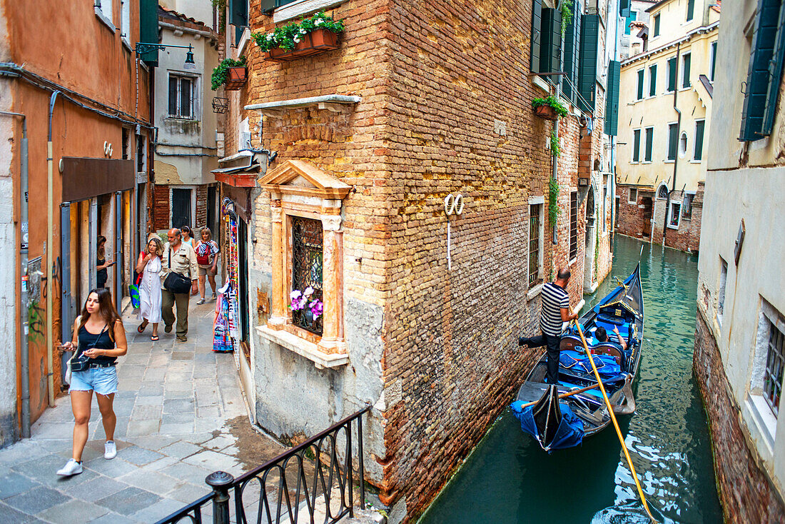 Fondamenta de l'Osmarin, San Marco, Venice, Italy alongside a canal with gondolas and gondolier in small canals. Gondolas, with tourists, near the Grand Canal, Venice, UNESCO, Veneto, Italy, Europe.