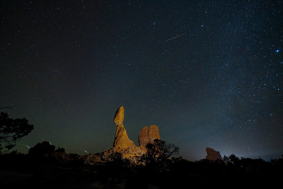 Geminiden-Meteoritenschauer über dem Balanced Rock im Arches National Park in Utah. Das zusammengesetzte Bild zeigt 10 Meteoriten über einen Zeitraum von 2 Stunden