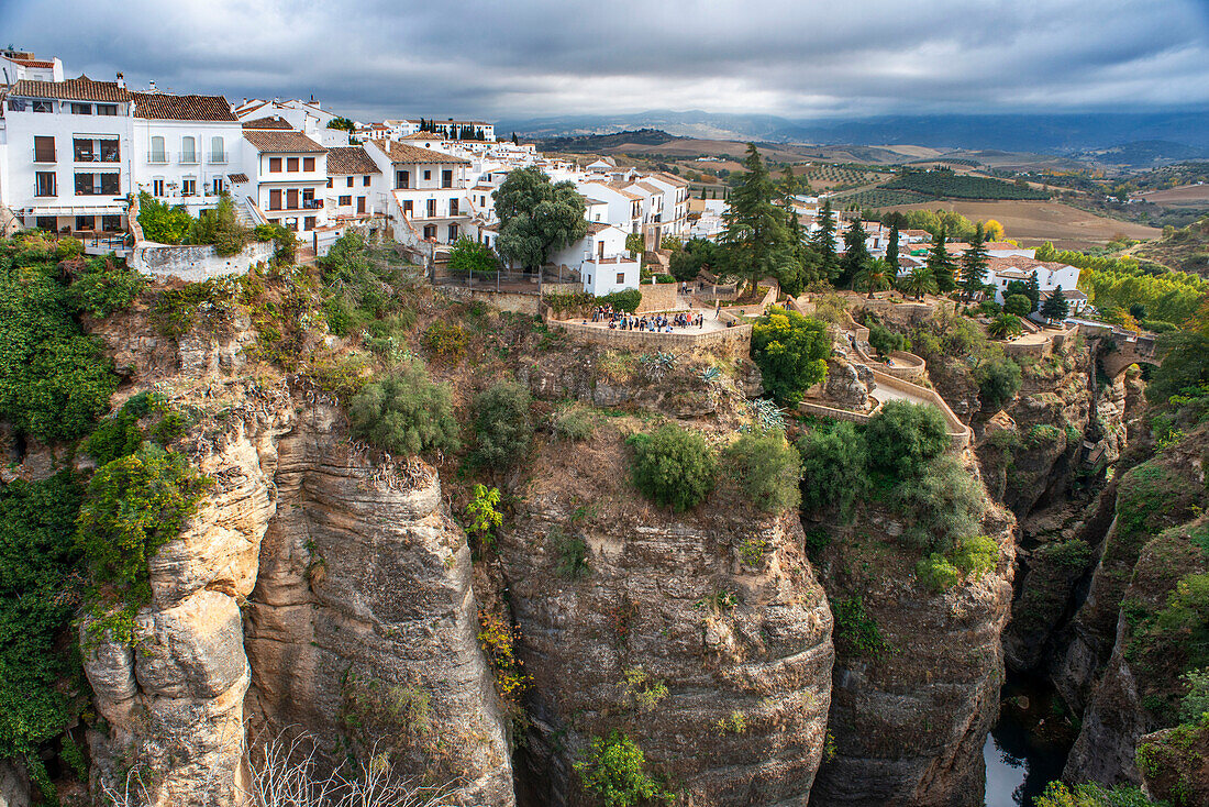 Landschaft mit weißen Häusern von der neuen Brücke Puente Nuevo und der Schlucht El Tajo, Ronda, Andalusien, Spanien