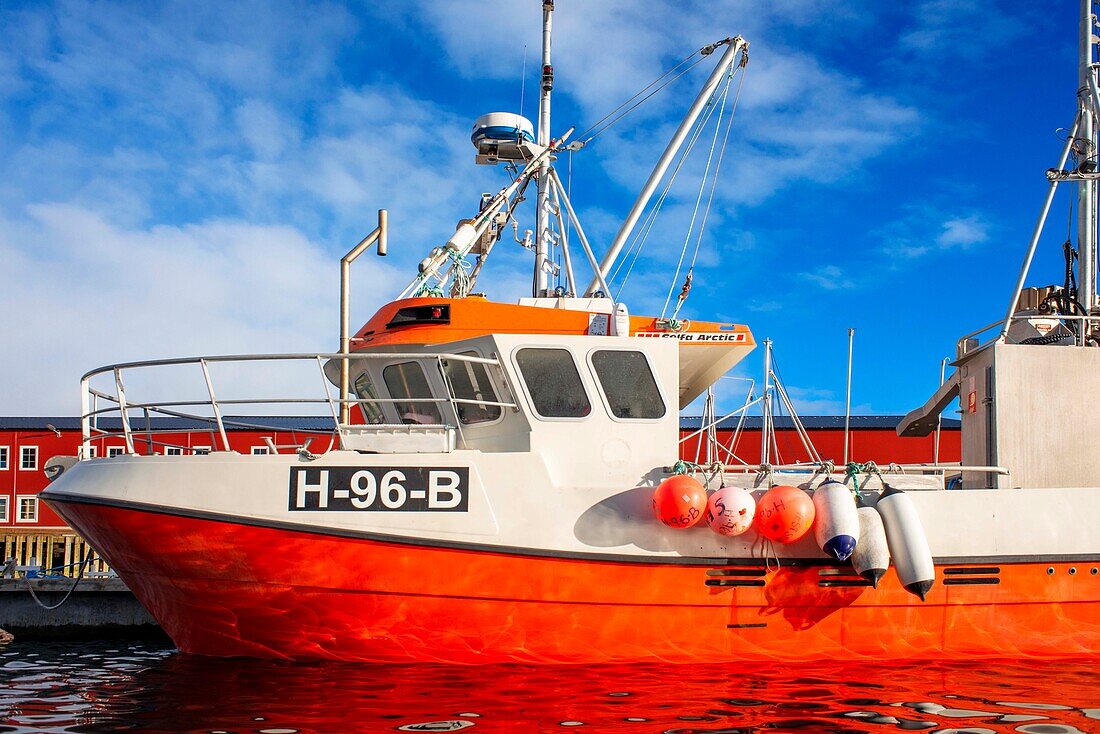 Rotes Fischerboot an einem Steg in Reine, Moskenes, Insel Moskenesøya, Lofoten, Norwegen