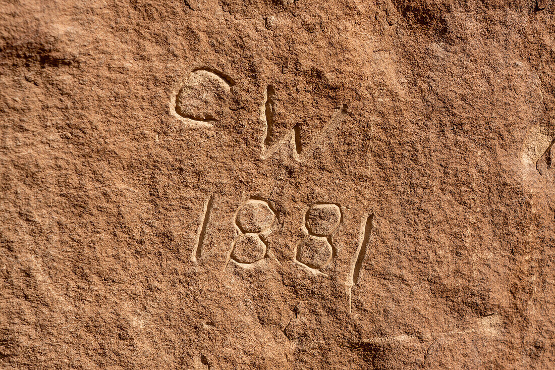 Historische Graffiti auf einer Tafel mit prähispanischer indianischer Felskunst im Nine Mile Canyon in Utah