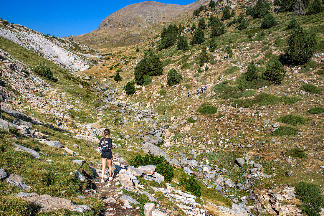 Rückansicht einer Frau, die zum Gipfel des Puigmal-Berges wandert, Katalonien, Pyrenäen, Spanien