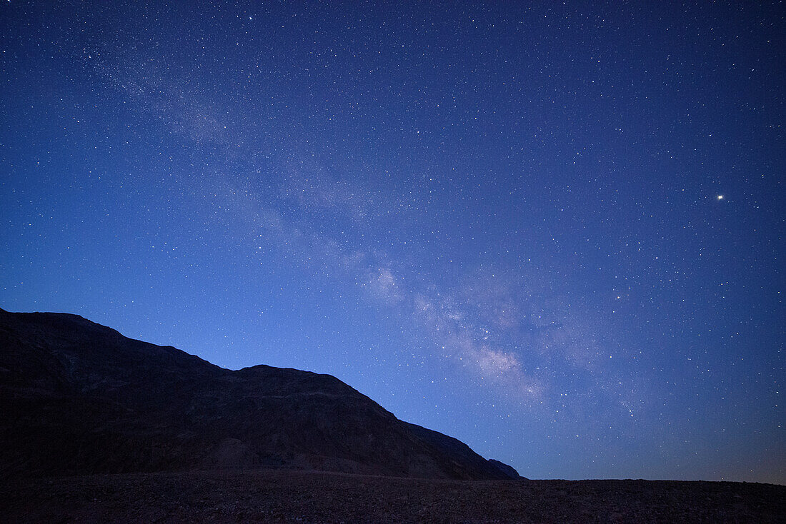 Milky Way over the Amargosa Range mountains from Badwater Basin in Death Valley National Park, California.