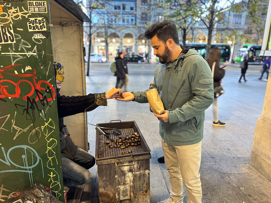 Man buying roasted chestnuts.