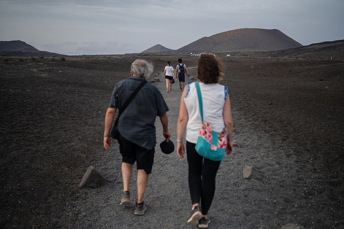 Volcan del Cuervo (Krähenvulkan), ein Krater, der auf einem Rundweg in einer kargen, felsdurchsetzten Landschaft erkundet wird