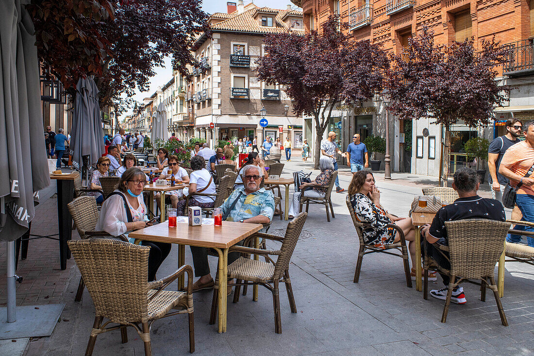 Restaurants Stehtische und Touristen, die in der Calle Libreros in Alcala de Henares, Madrid, speisen