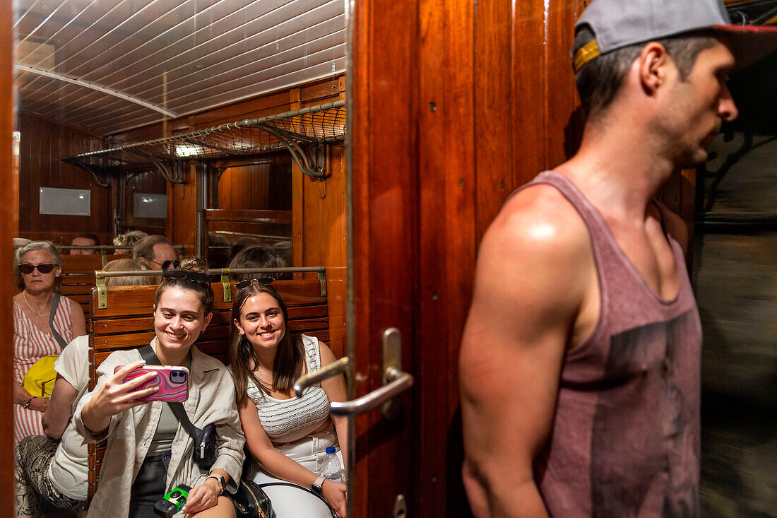 Tourists inside of tren de Soller train vintage historic train that connects Palma de Mallorca to Soller, Majorca, Balearic Islands, Spain, Mediterranean, Europe.