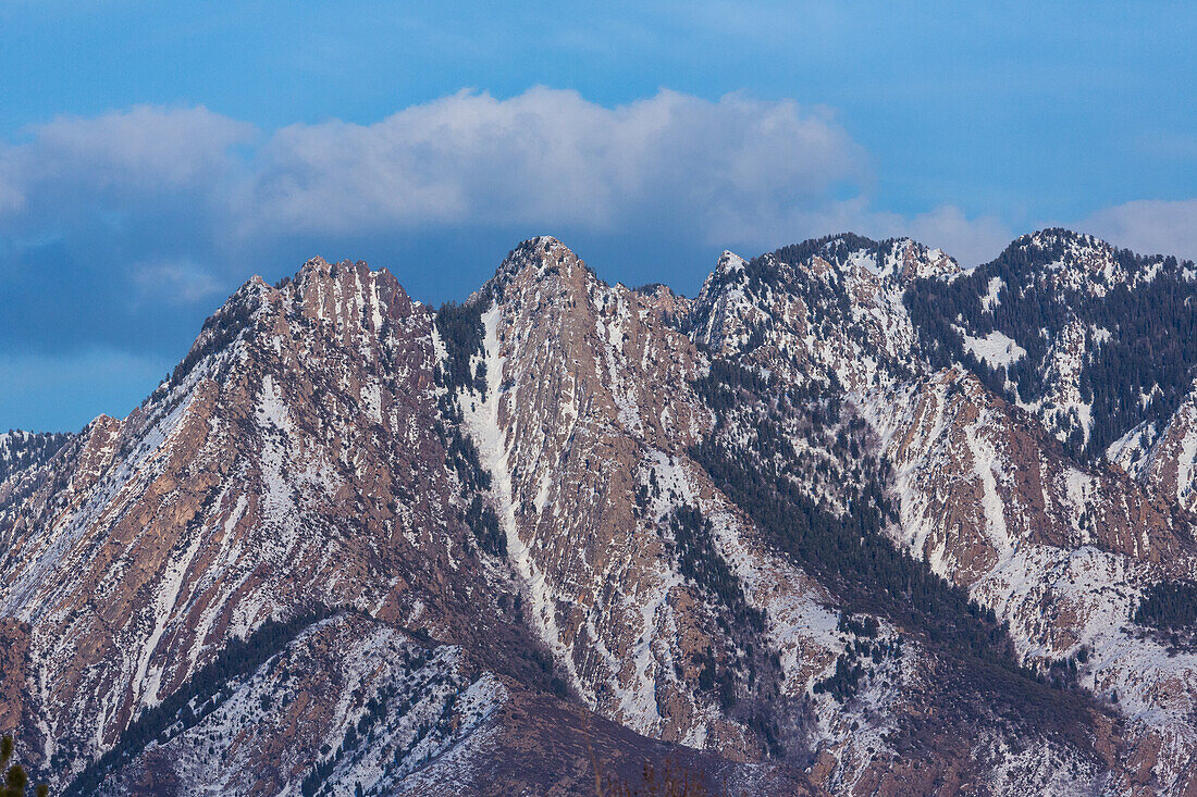 Clouds over snowy Mount Olympus in the Wasatch Mountain Range by Salt Lake City, Utah.