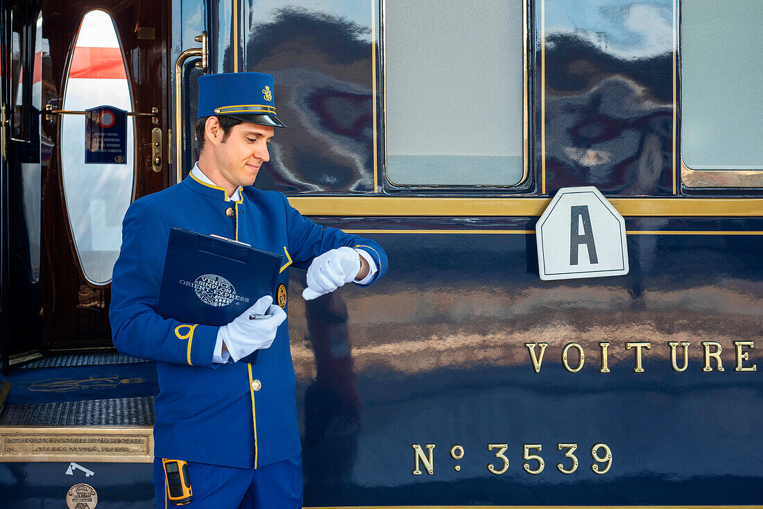 Staff of Belmond Venice Simplon Orient Express luxury train stoped at Venezia Santa Lucia railway station the central railway station in Venice Italy.