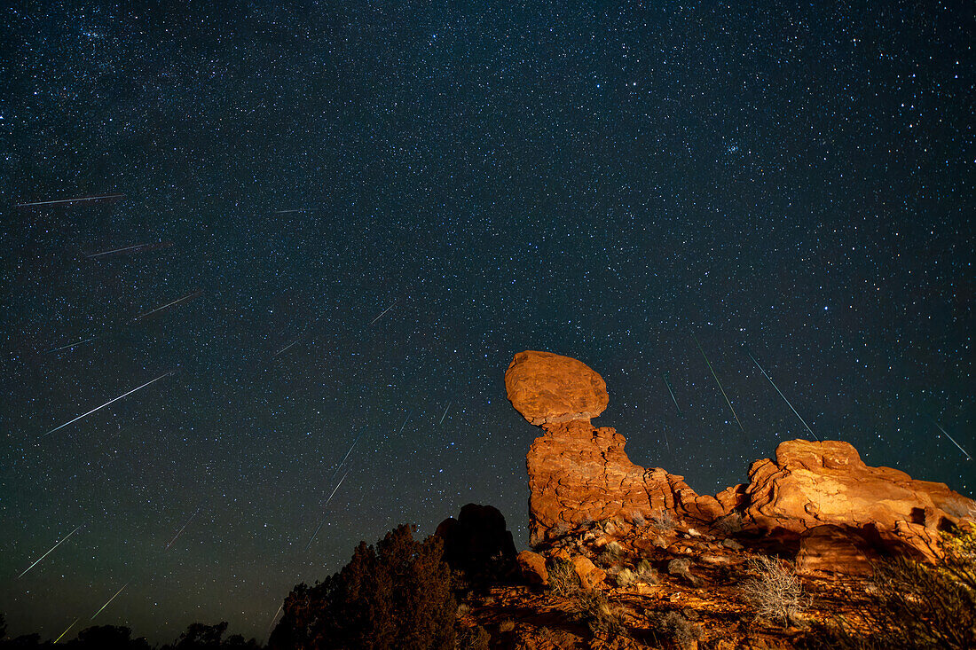 Geminiden-Meteoritenschauer über dem Balanced Rock im Arches National Park in Utah. Das zusammengesetzte Bild zeigt 23 Meteoriten über einen Zeitraum von 2 Stunden