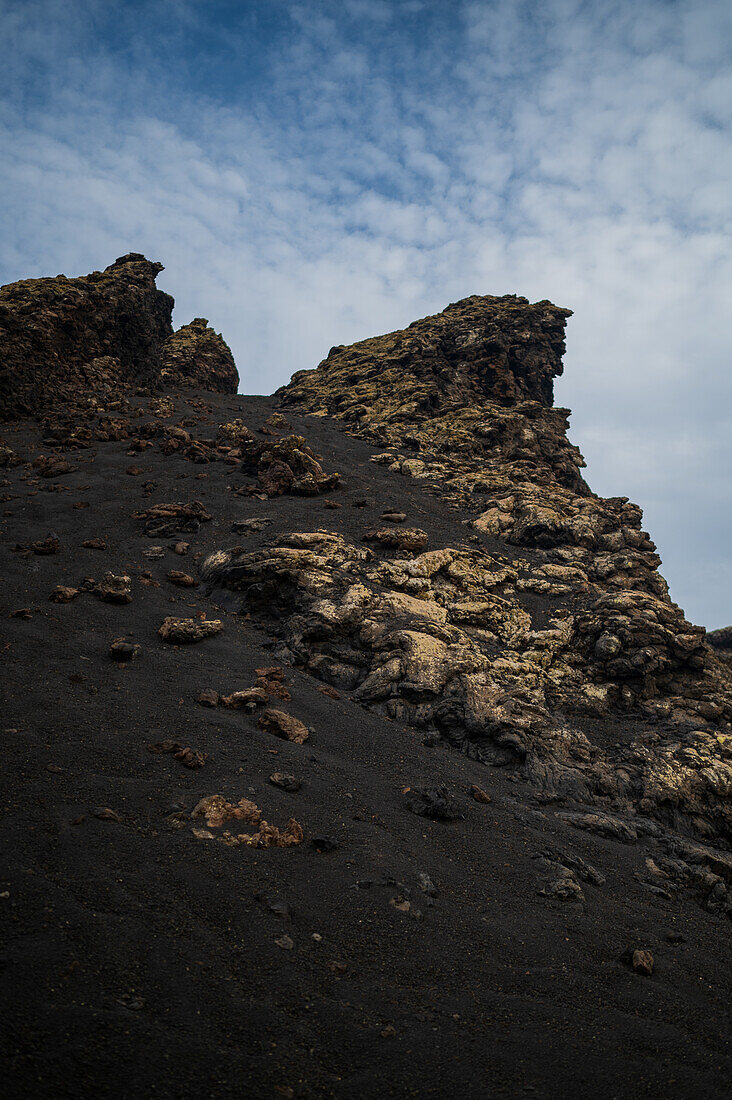 Volcan del Cuervo (Krähenvulkan), ein Krater, der auf einem Rundweg in einer kargen, felsigen Landschaft erkundet wird