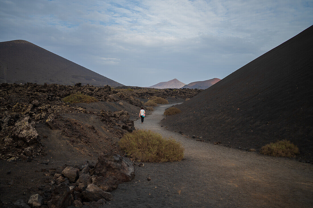 Volcan del Cuervo (Krähenvulkan), ein Krater, der auf einem Rundweg in einer kargen, von Felsen übersäten Landschaft erkundet wird