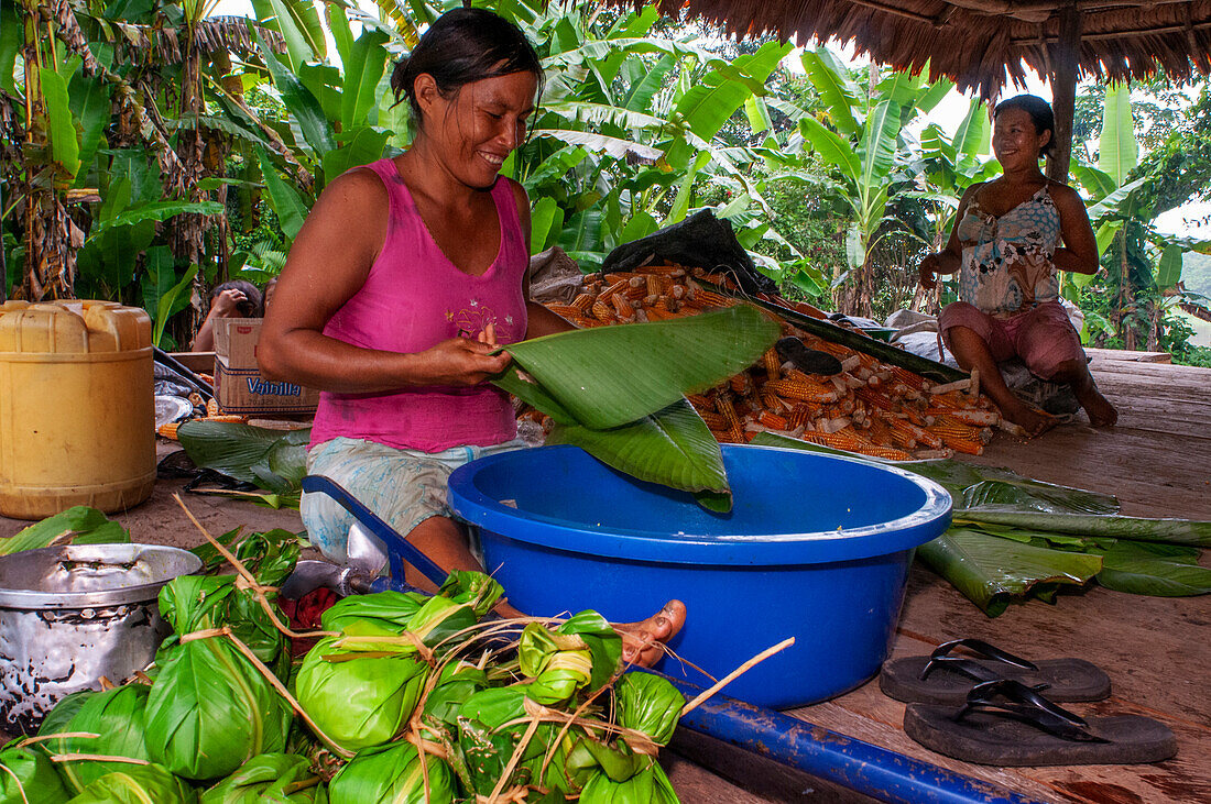 Frau bereitet Juanes hausgemachte Mais- und Hühnertamales nach traditioneller Methode in Timicuro I, Iqutios peruanischer Amazonas, Loreto, Peru