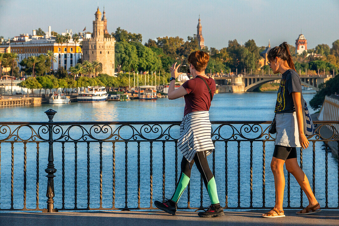 Tourists in Guadalquivir river and The Torre del Oro what translates to Tower of Gold - historical landmark from XIII century in Seville, Andalusia, Spain
