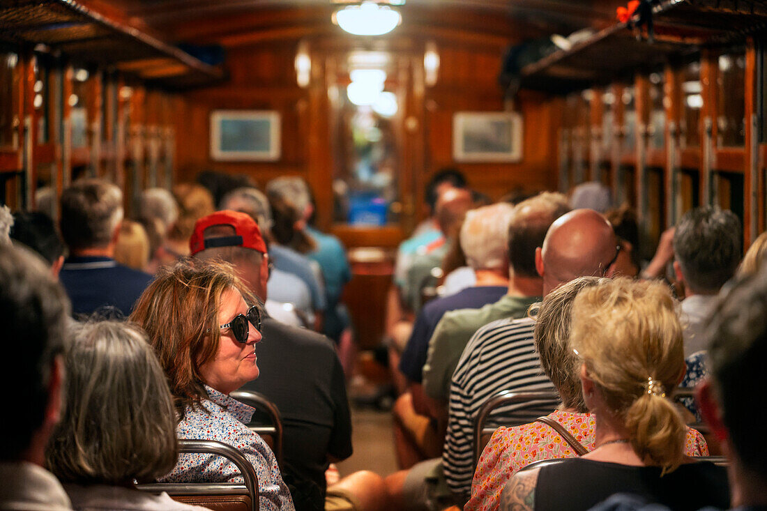 Tourists inside of tren de Soller train vintage historic train that connects Palma de Mallorca to Soller, Majorca, Balearic Islands, Spain, Mediterranean, Europe.