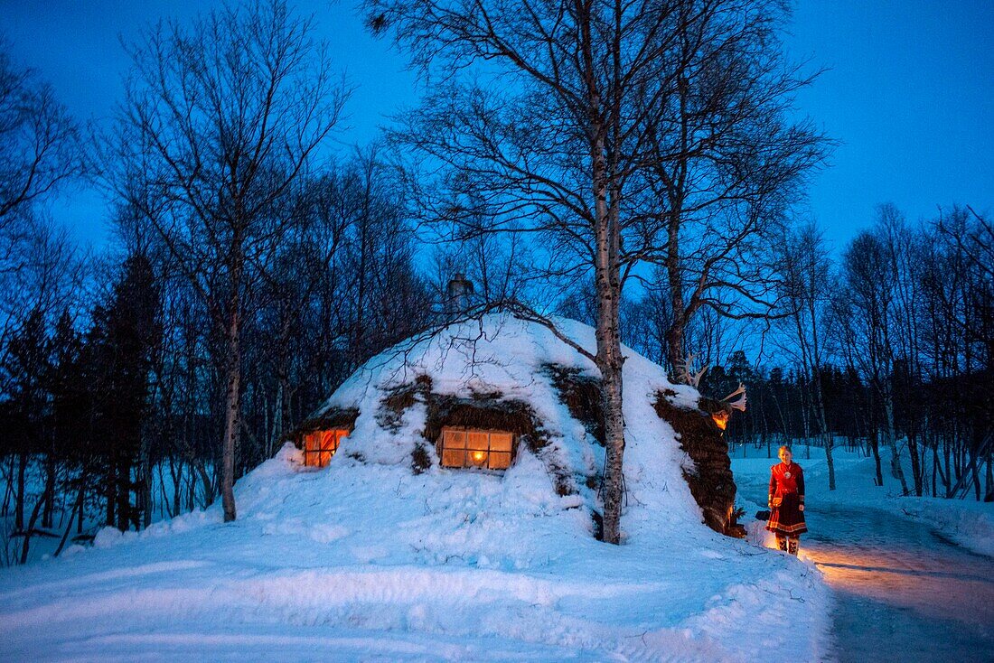 Sami woman and her house in Lønsdal Storjord, Norway. Saltfjellet-Svartisen national park.