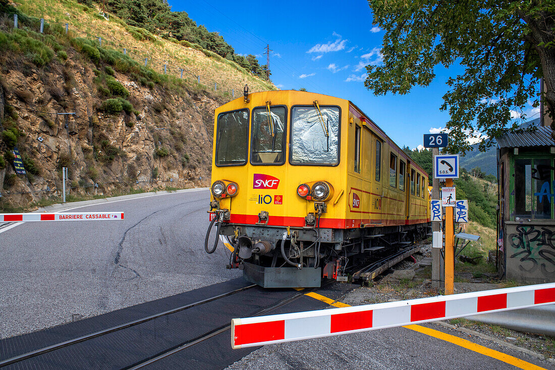 Level crossing The Yellow Train or Train Jaune in Maison de garde-barrière and N116 road between Sauto and Planès, Pyrénées-Orientales, Languedoc-Roussillon, France.