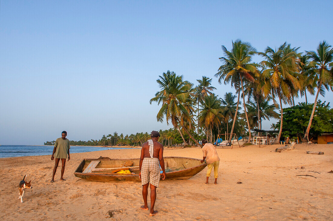 Einheimische Fischer am Strand von Las Terrenas, Samana, Dominikanische Republik, Karibik, Amerika. Tropischer Karibikstrand mit Kokosnusspalmen