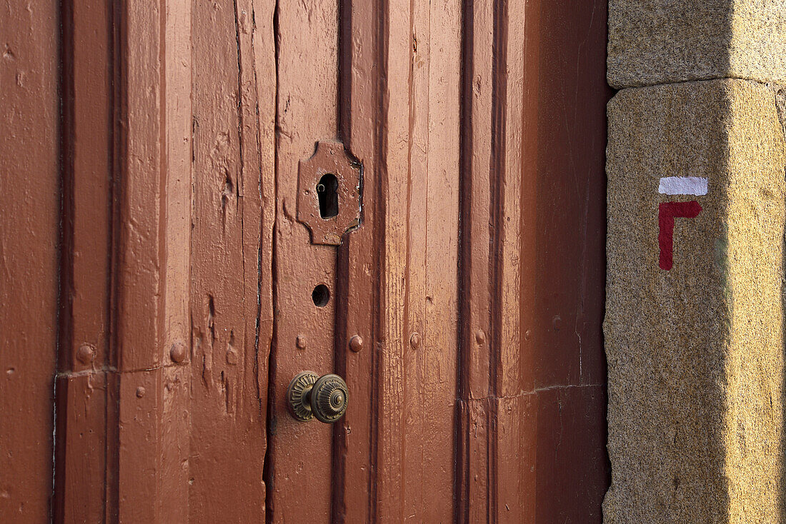 Hiking signal painted over a door in Pinhel, Portugal.