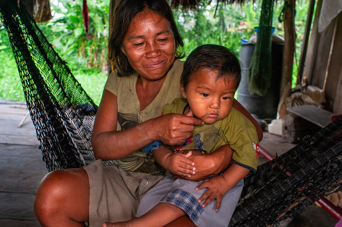 Einheimische Familie in dem am Fluss gelegenen Dorf Timicuro I. Iqutios im peruanischen Amazonasgebiet, Loreto, Peru