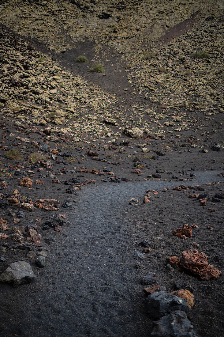 Volcan del Cuervo (Krähenvulkan), ein Krater, der über einen Rundweg in einer kargen, felsigen Landschaft erkundet werden kann