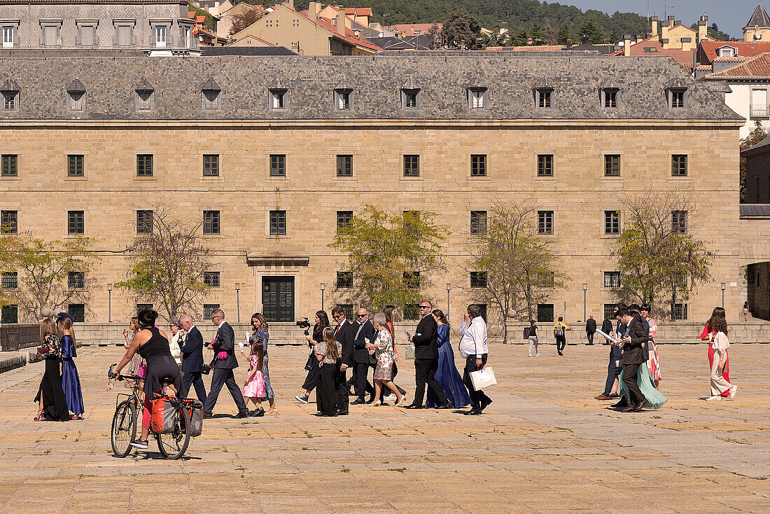Mädchen auf dem Fahrrad, das die Hochzeitsgäste über die Lonja des Klosters San Lorenzo beobachtet. San Lorenzo de El Escorial, Madrid