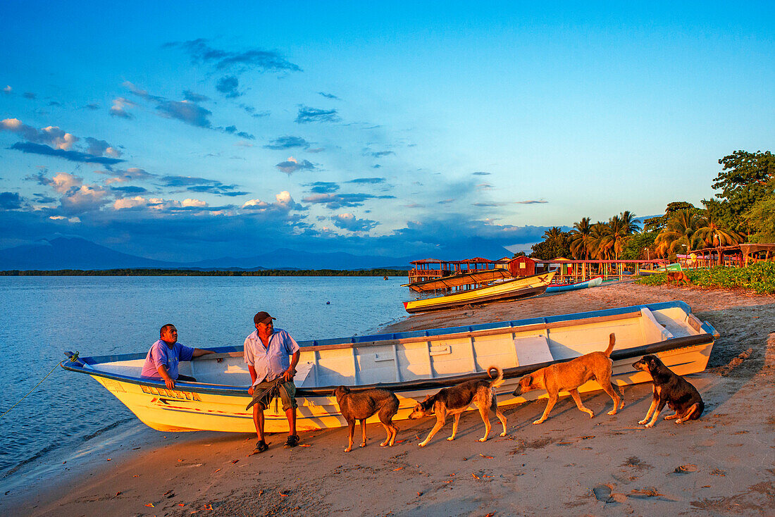 Hunde und Fischerboote am Strand der Insel La Pirraya, Usulutánin der Jiquilisco-Bucht im Golf von Fonseca im Pazifischen Ozean, El Salvador, Mittelamerika