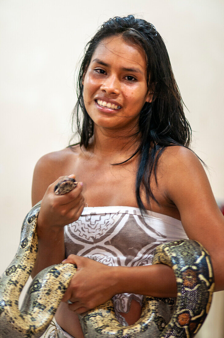 Eine Amazonas-Baumboa mit einem indigenen Yagua-Mädchen aus dem Dschungeldach im Yasuni-Nationalpark im Amazonasgebiet, einem der artenreichsten Orte der Erde