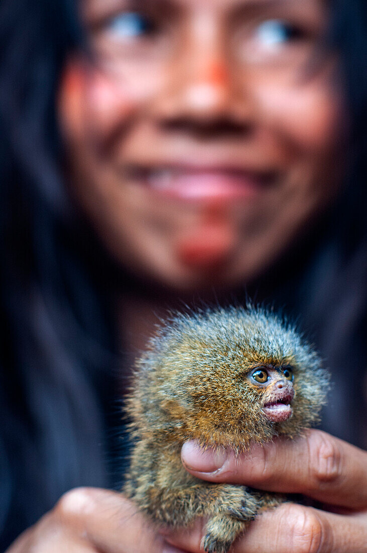 Pet pygmy marmoset Yagua Indians living a traditional life near the Amazonian city of Iquitos, Peru.