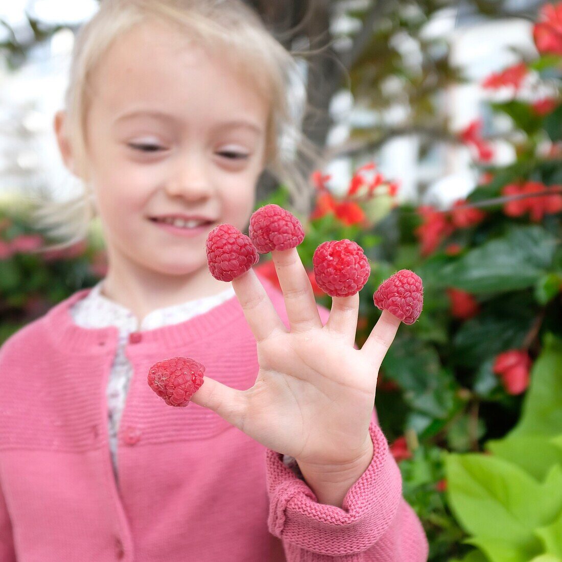 Frankreich, Val de Marne, Charenton le Pont, Mädchen spielt mit Himbeeren