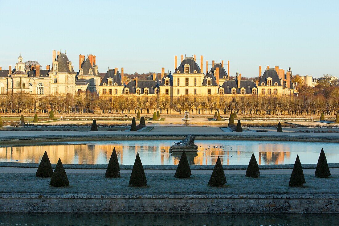 France, Seine et Marne, Fontainebleau, Fontainebleau royal castle listed as UNESCO World Heritage, general view pf the gardens by Andre Le Notre and reflection of the castle in the basin oramented with a statue representing the Tibre