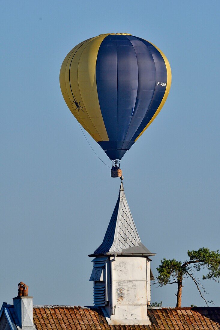 Frankreich, Doubs, Brognard, Heißluftballon fliegt über den Kirchturm der Dorfschule