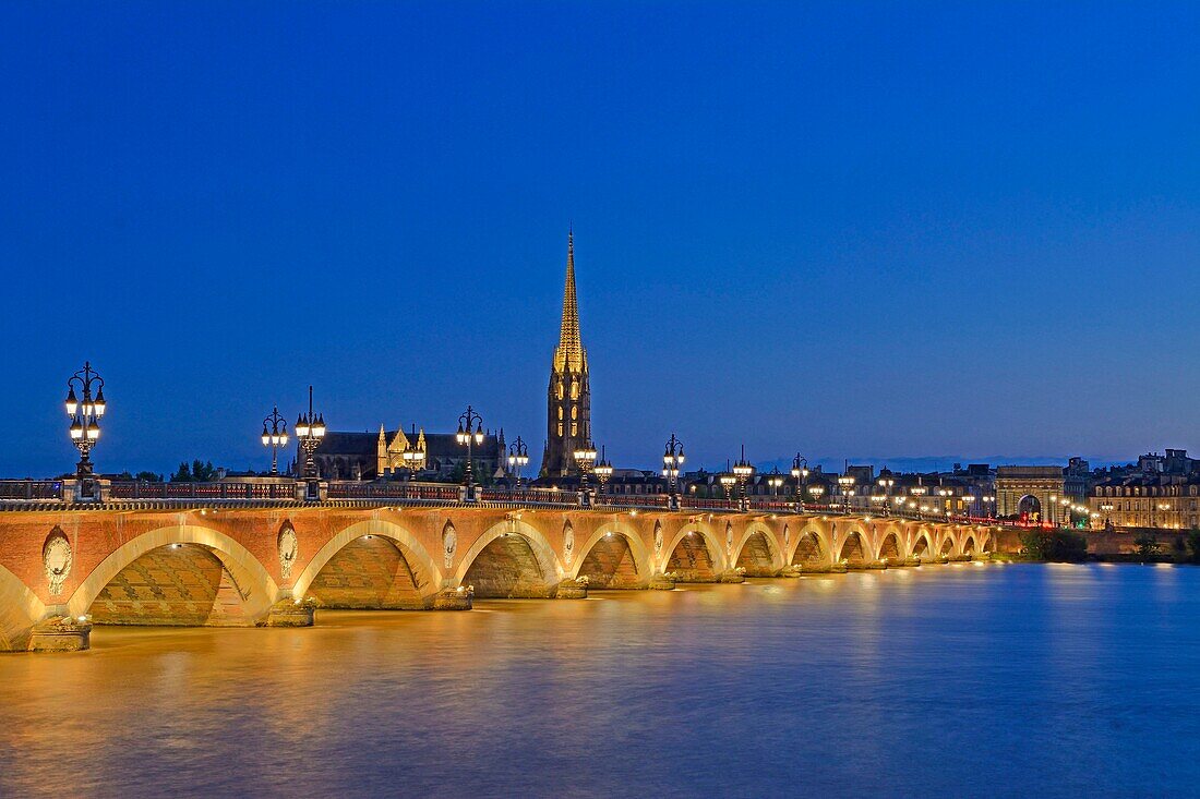 France, Gironde, Bordeaux, area listed as World Heritage by UNESCO, stone bridge over the Garonne river, brick and stone arch bridge inaugurated in 1822, and Saint Michel basilica in the background