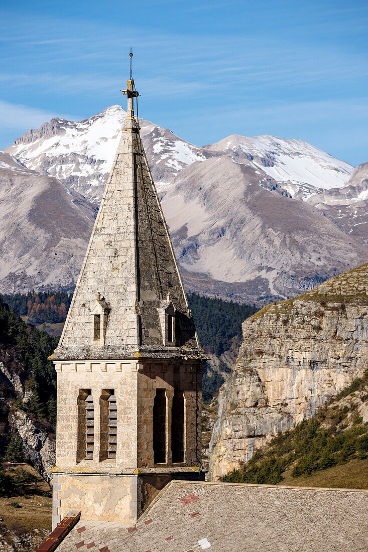 France, Hautes Alpes, Dévoluy massif, Saint Etienne en Dévoluy, steeple of the Saint Étienne church, in the background the summit of the Tête de l'Aupet (2627m)